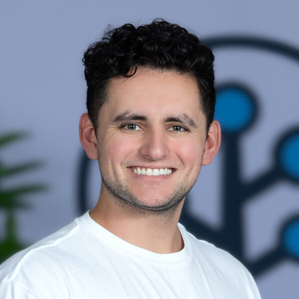 Man with brown hair and white tshirt smiling